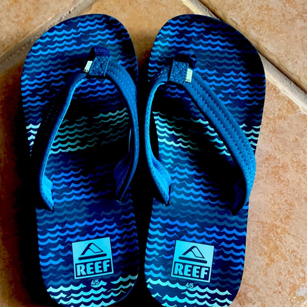 Boys black and Blue pair of Reef flip flops and Sperry flip flops .